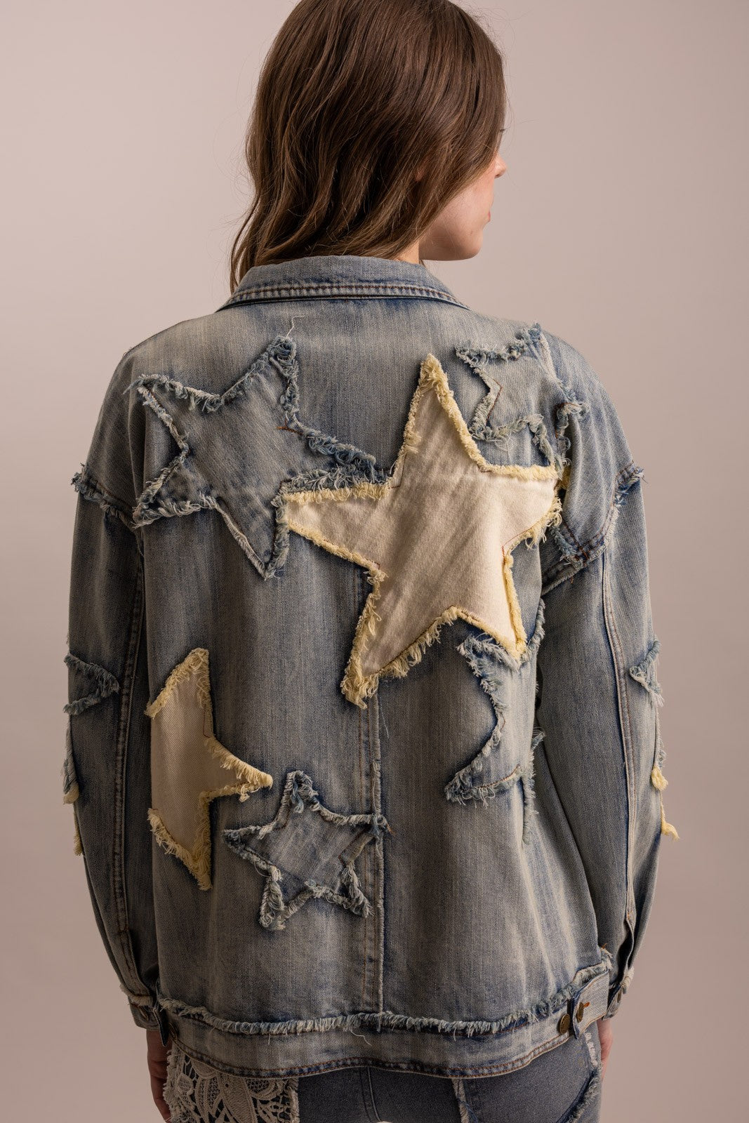 Back view of BlueVelvet oversized denim jacket with large distressed ivory and denim star appliqués