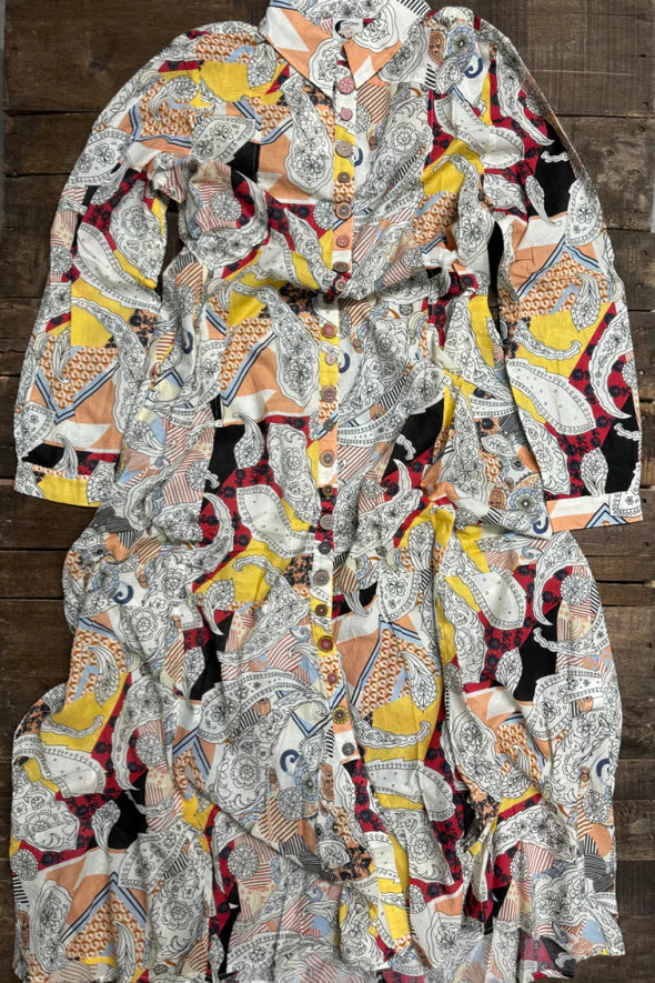 Woman wearing the Paisley Skies Duster Dress by Jaded Gypsy featuring colorful paisley print, hand-painted mandala buttons, and flowing lightweight cotton fabric.