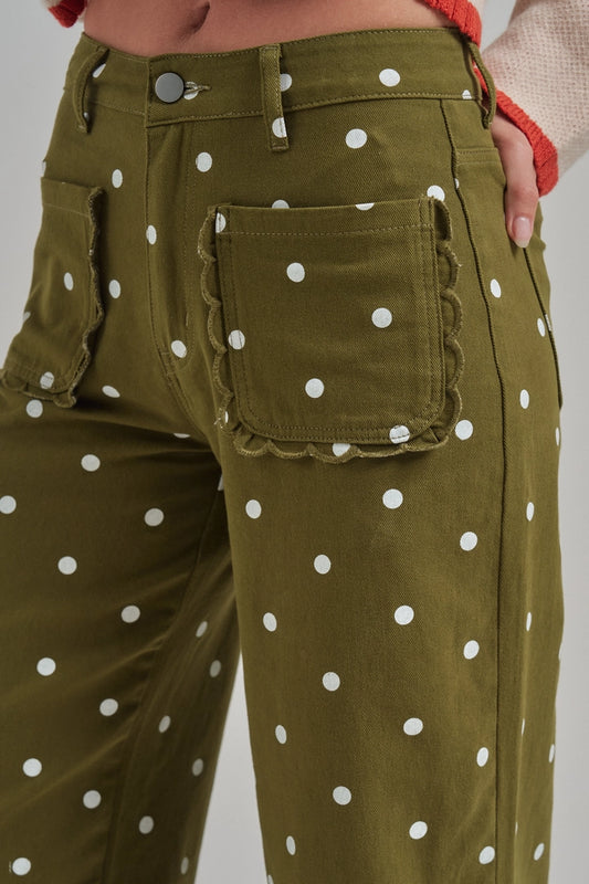 Close-up of olive polka dot twill pants featuring scalloped patch pockets and button waist.