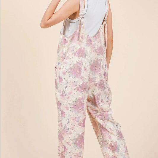 Petal & Promise Eyelet Jumpsuit by Gee Gee featuring floral eyelet embroidery, adjustable straps, roomy boho fit, and front pockets.