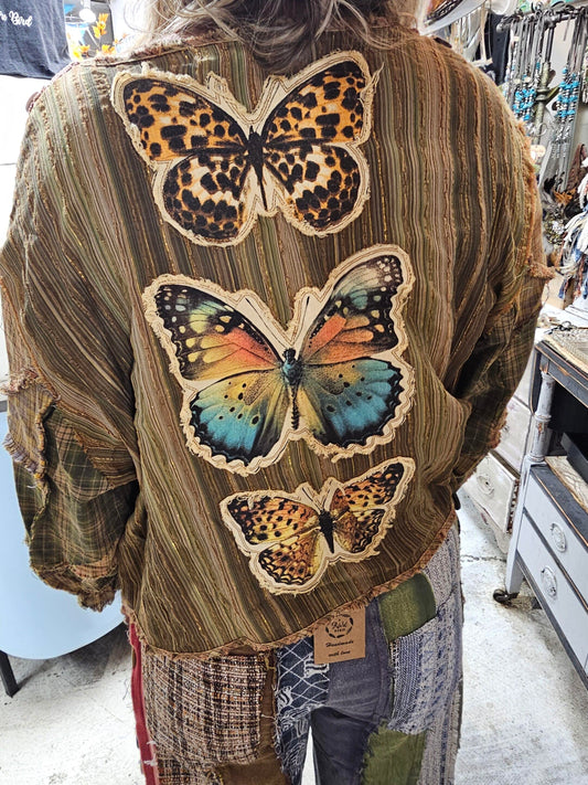A Beautifil Olive Green and Gold Lurex Striped Lightweight Jacket by A Rare Bird. This overlay, jacket, features Applique butterflies on the back and multicolored, vintage insired, buttons on the front with crotched detail and a tie front for closure. Design by A Rare Bird