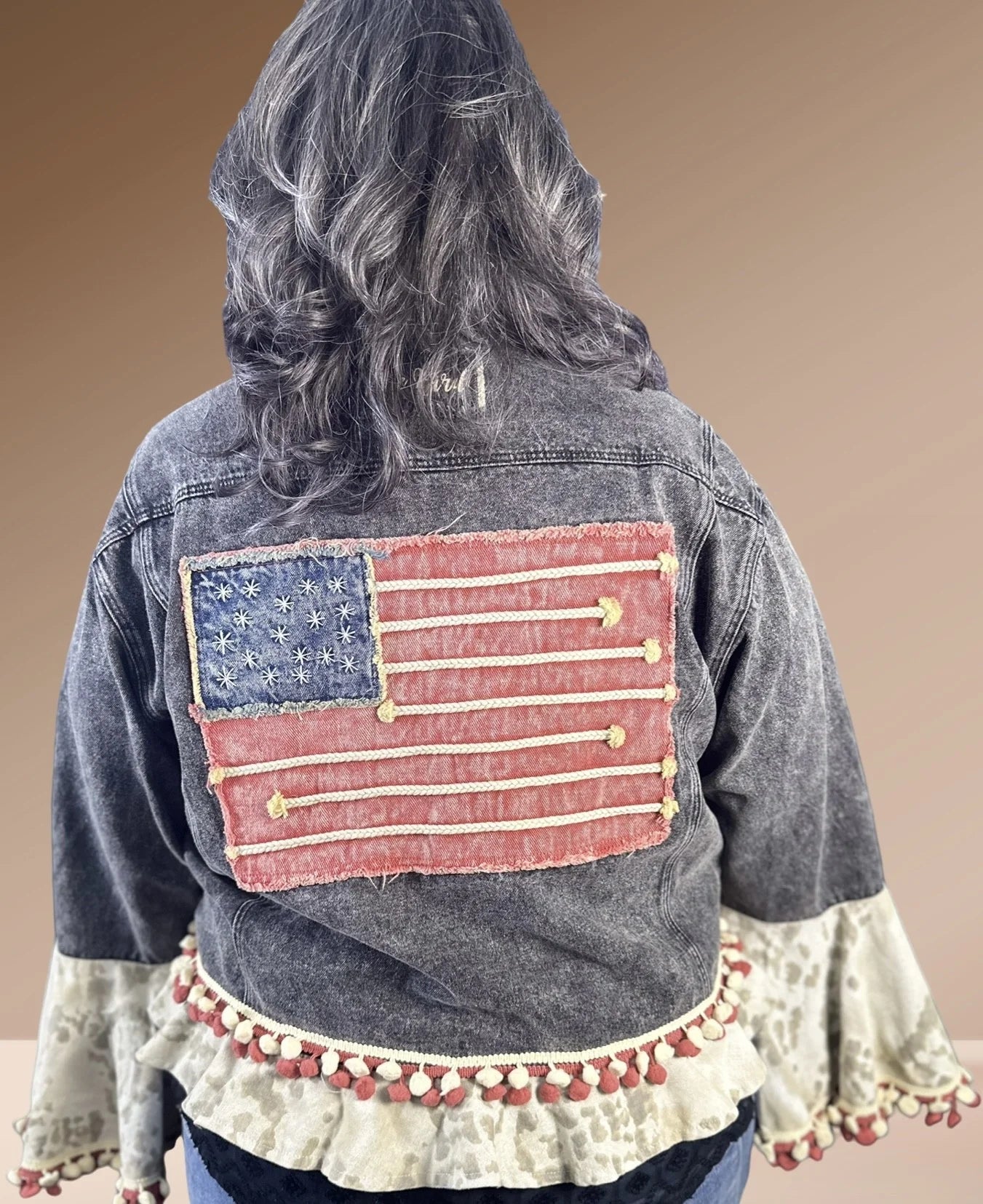 Handmade mineral-washed black denim jacket with embroidery, pom details, and bell sleeves by A Rare Bird, one-size fits 4–18.