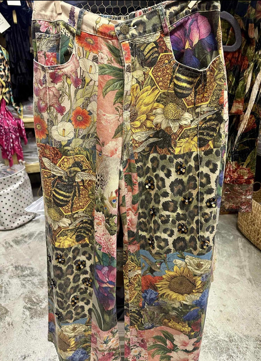 Multicolored patterned pants with floral, leopard, and bee designs on a store floor. Boho-chic. Unique Clothing.
By A Rare Bird