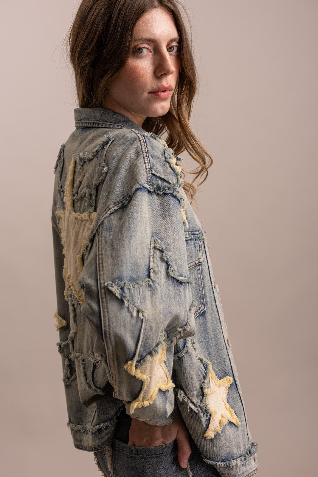 Side view of distressed star appliqué denim jacket by BlueVelvet with vintage wash and frayed fabric detailing