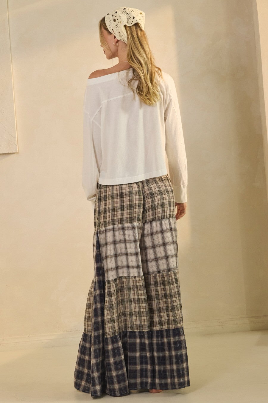 Model wearing patchwork plaid wide-leg boho pants with elastic drawstring waist and pockets from Oceans of Time Boutique in Newport, Oregon.

