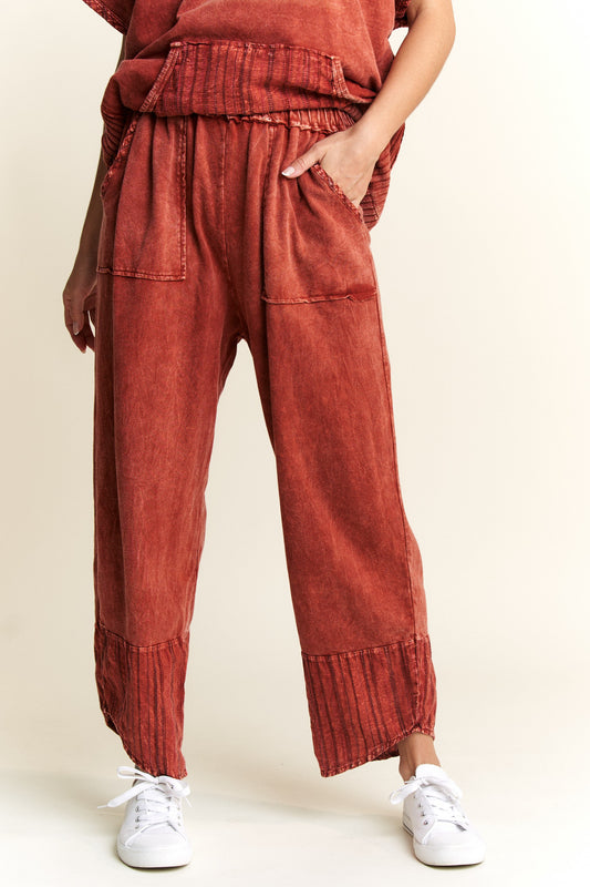 Burnt orange mineral wash capri pants with elastic waist, pockets, and navy striped contrast hem detail