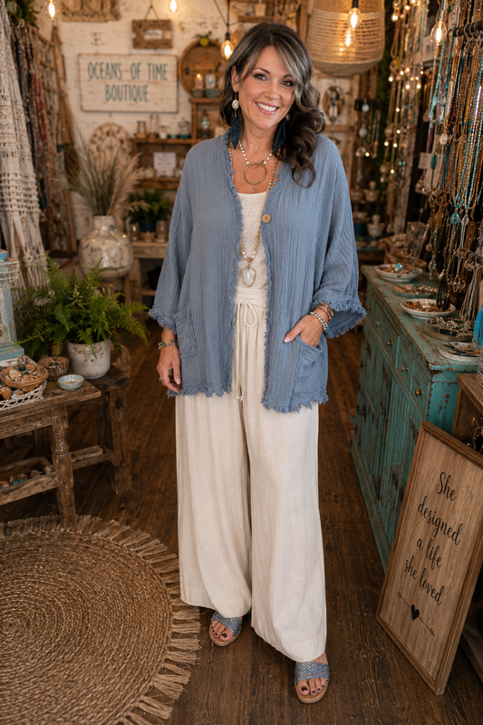 Blue Heron Cotton Gauze Jacket by Evergreen Guardian featuring soft blue-grey 100% cotton gauze, wooden button front, frayed hem, front pockets, and a relaxed boho silhouette.