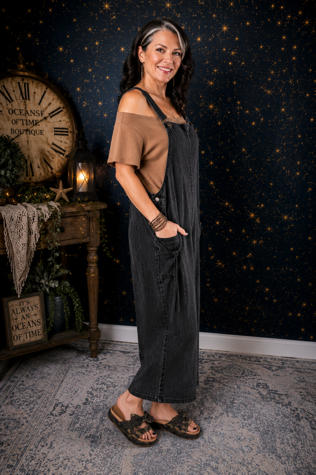 Black cotton wide-leg overalls by Evergreen Guardian featuring adjustable straps, front bib pocket, front pockets, and a relaxed oversized boho silhouette.