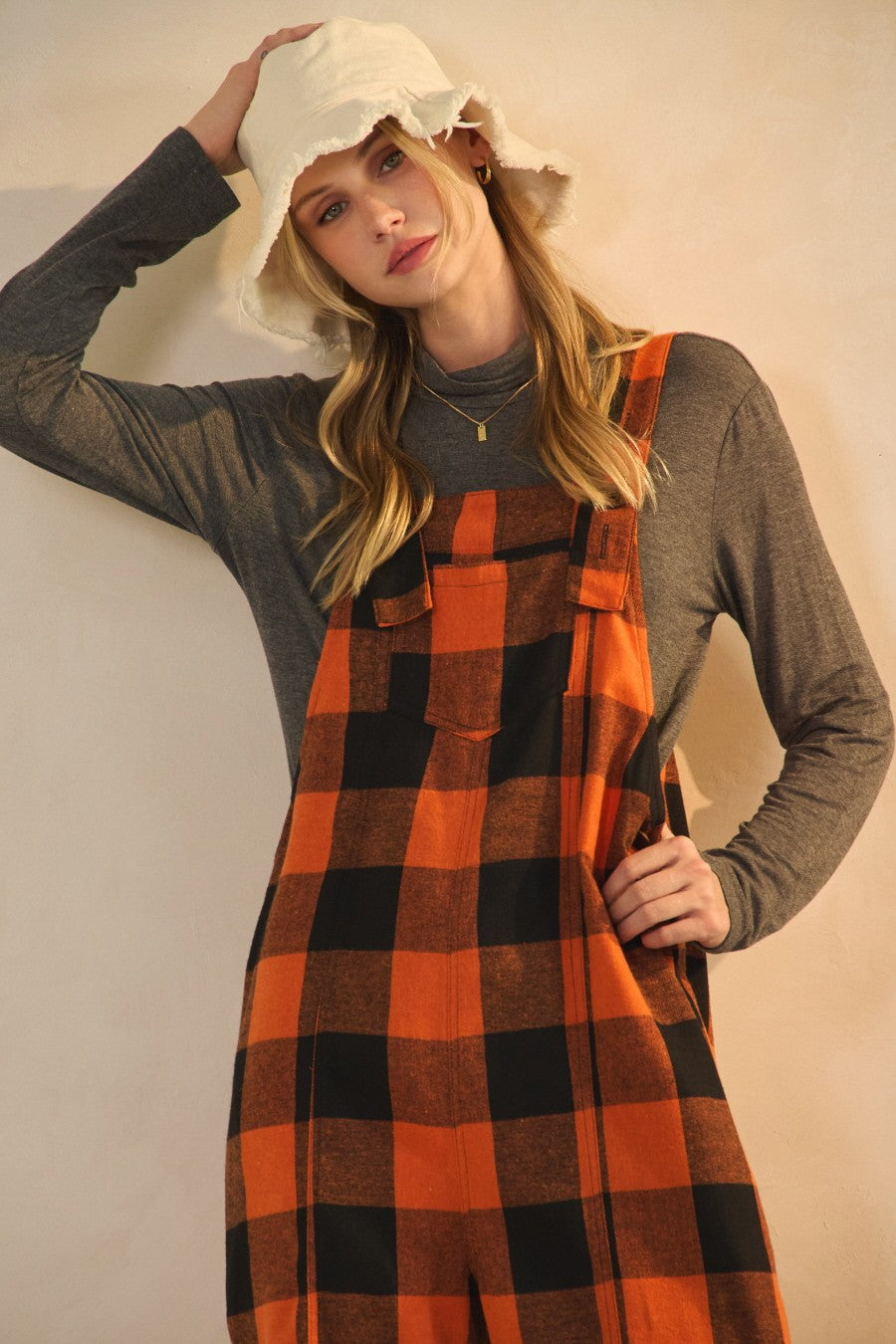 Orange and black buffalo plaid cropped overalls with wide leg fit and adjustable straps styled for fall outfit
