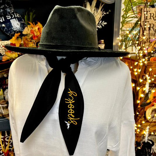 Black Spooky Halloween ascot scarf with orange embroidered lettering styled around a black wide brim hat