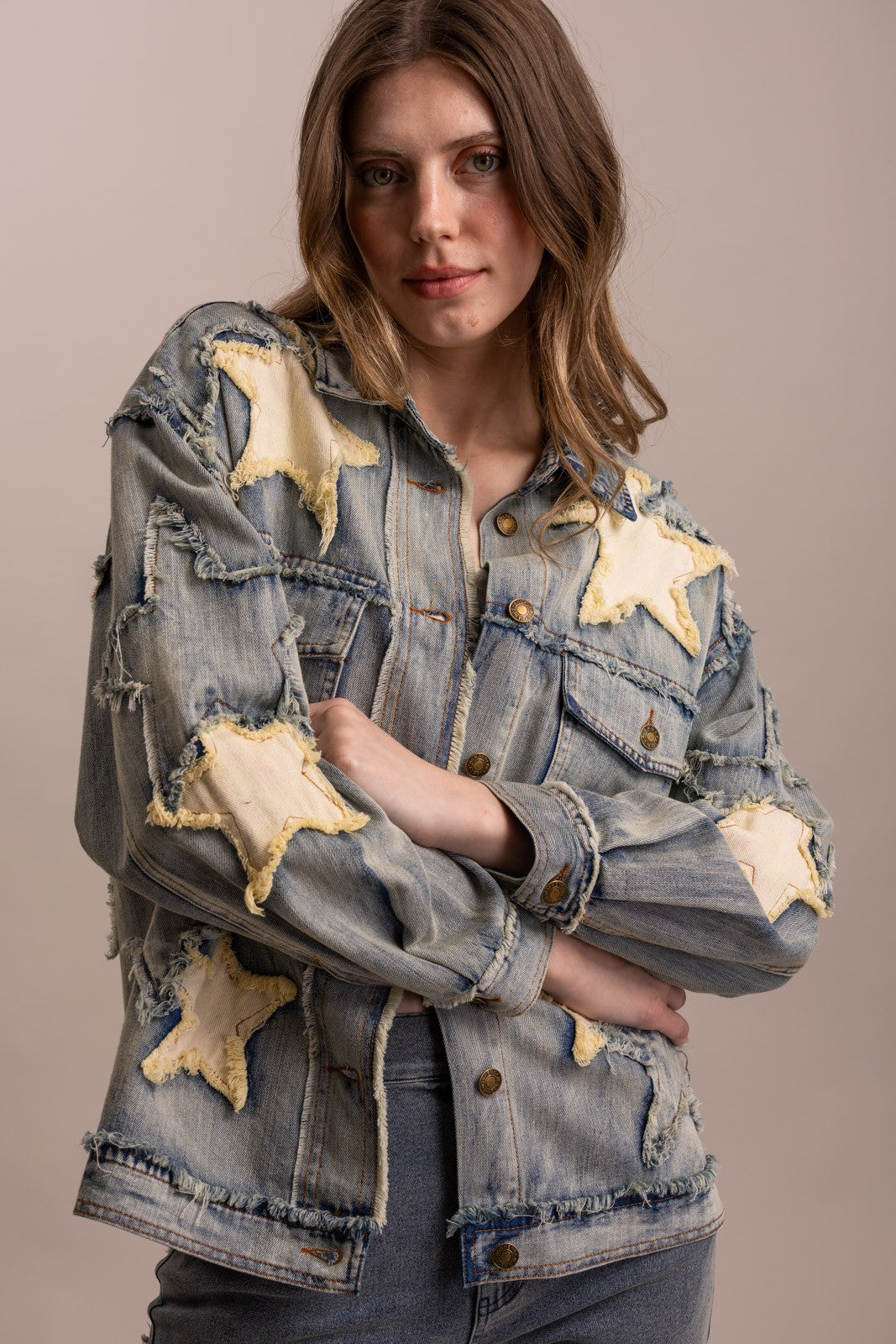 Front view of BlueVelvet oversized washed denim jacket with distressed ivory star appliqués and button-front chest pockets