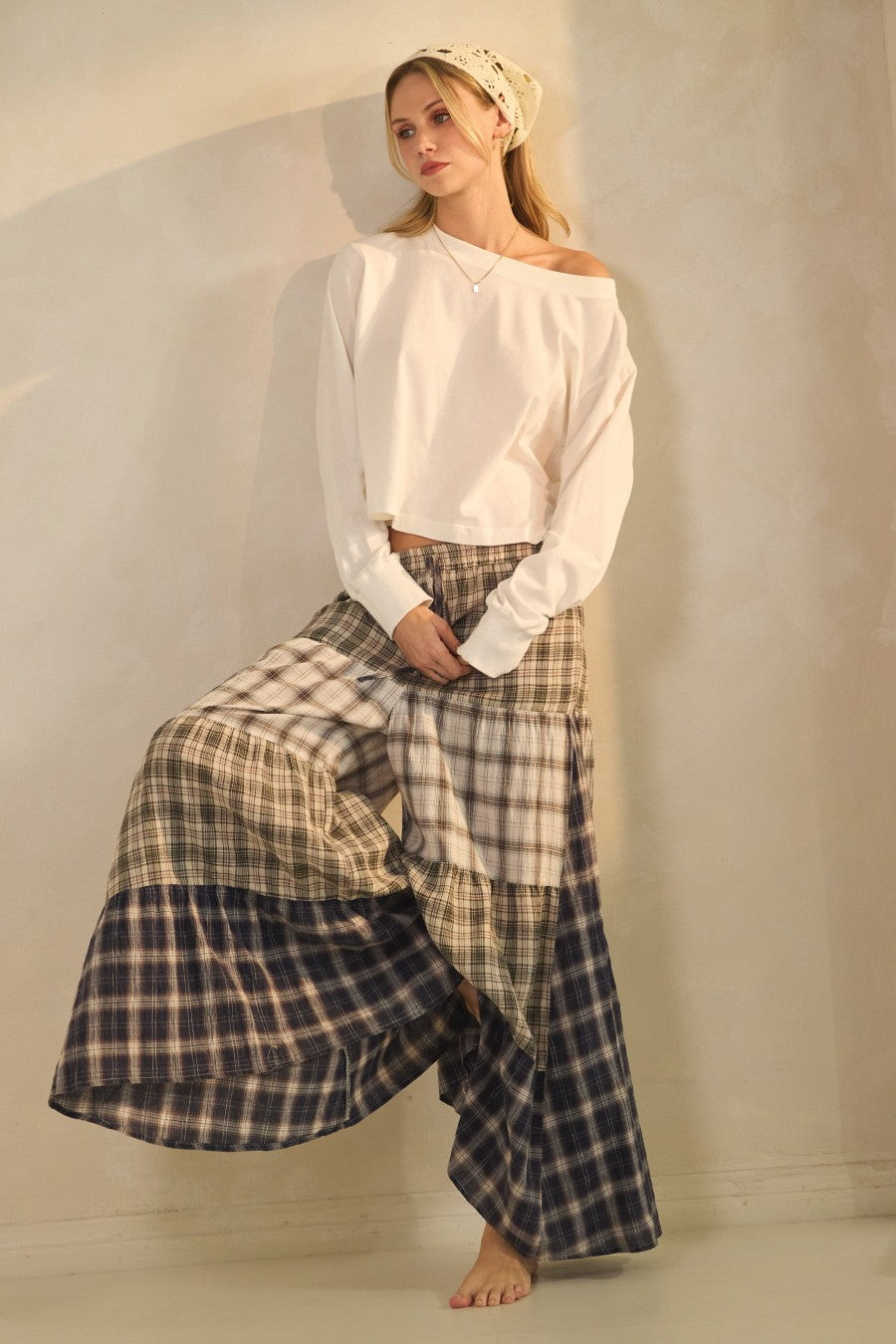 Model wearing patchwork plaid wide-leg boho pants with elastic drawstring waist and pockets from Oceans of Time Boutique in Newport, Oregon.

