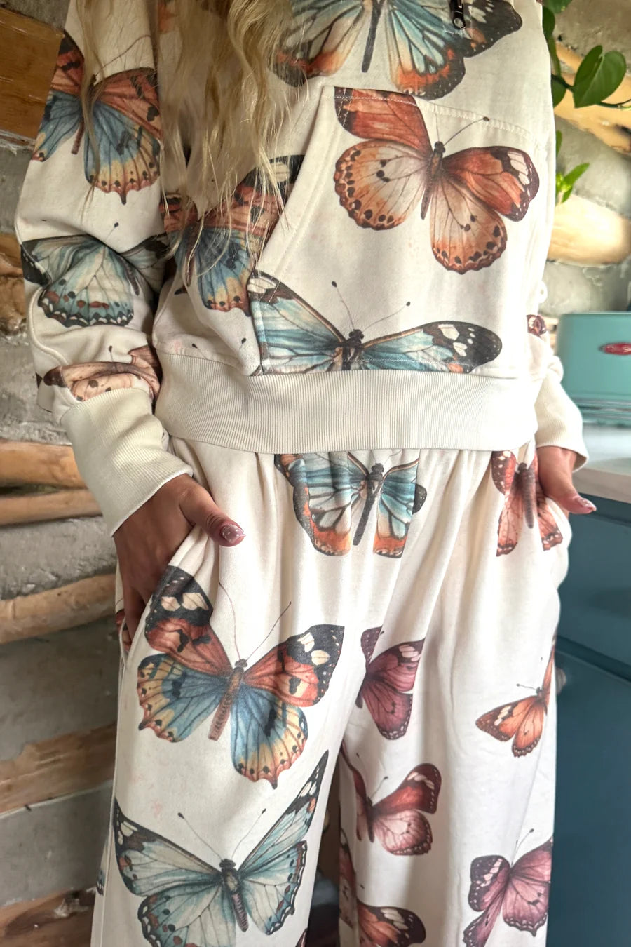 Close-up of Blakeley butterfly pullover showing front kangaroo pocket, washed butterfly print and ribbed hem