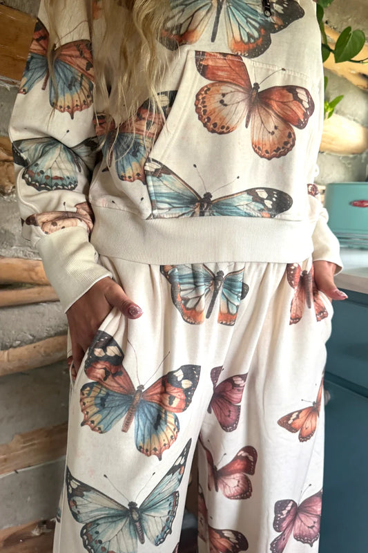 Close-up of Blakeley butterfly pullover showing front kangaroo pocket, washed butterfly print and ribbed hem