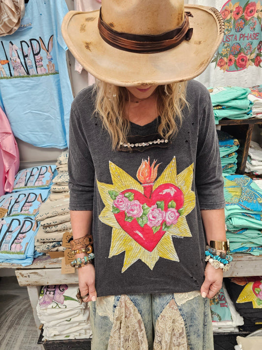 Charcoal tattered 3/4 sleeve cotton tee with large Sacred Heart and rose graphic, worn with boho accessories and lace denim.