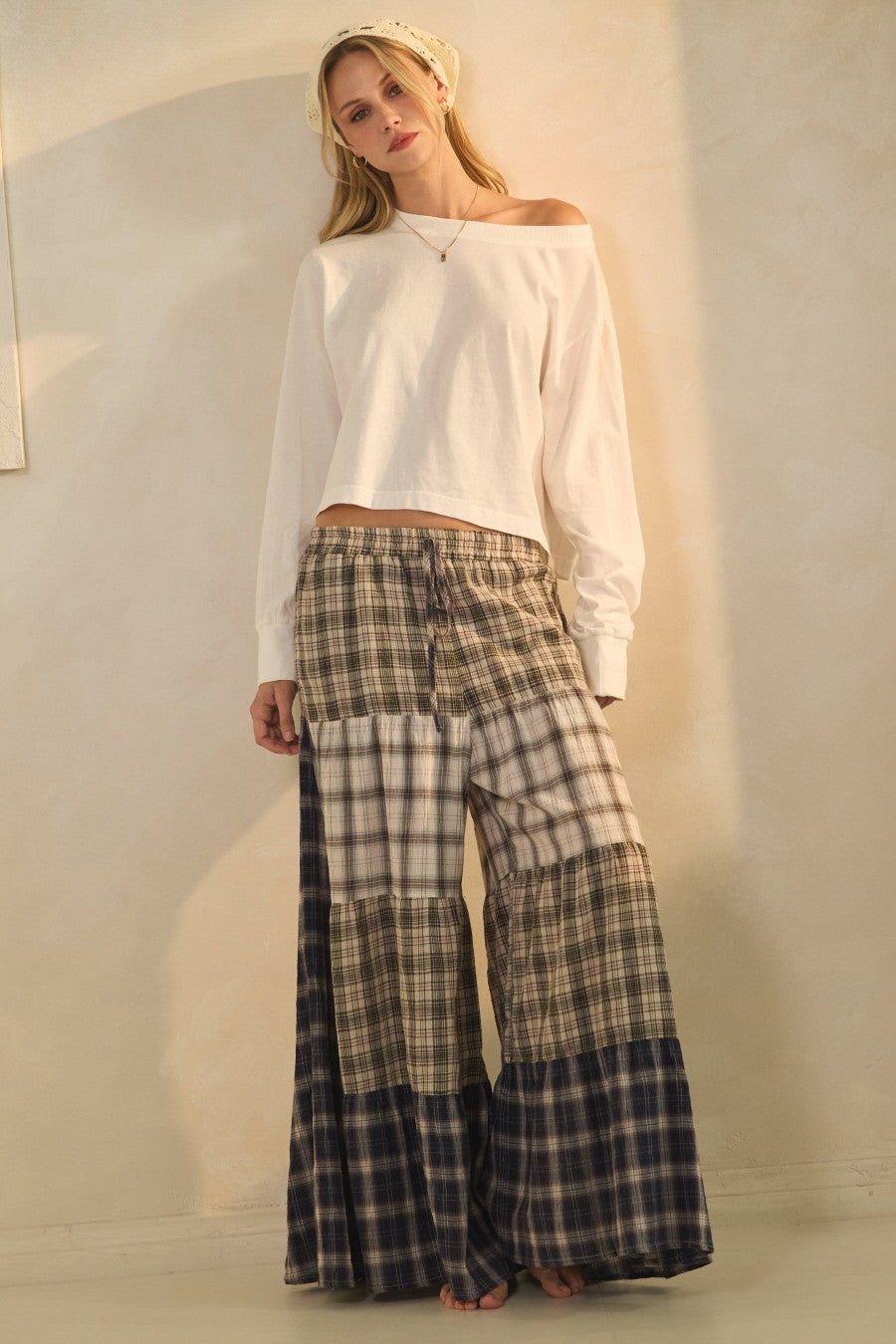 Model wearing patchwork plaid wide-leg boho pants with elastic drawstring waist and pockets from Oceans of Time Boutique in Newport, Oregon.
